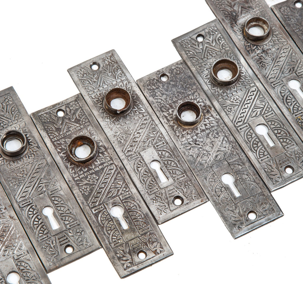 group of 8 matching late 19th century antique american salvaged chicago "windsor" pattern wrought steel doorknob backplates