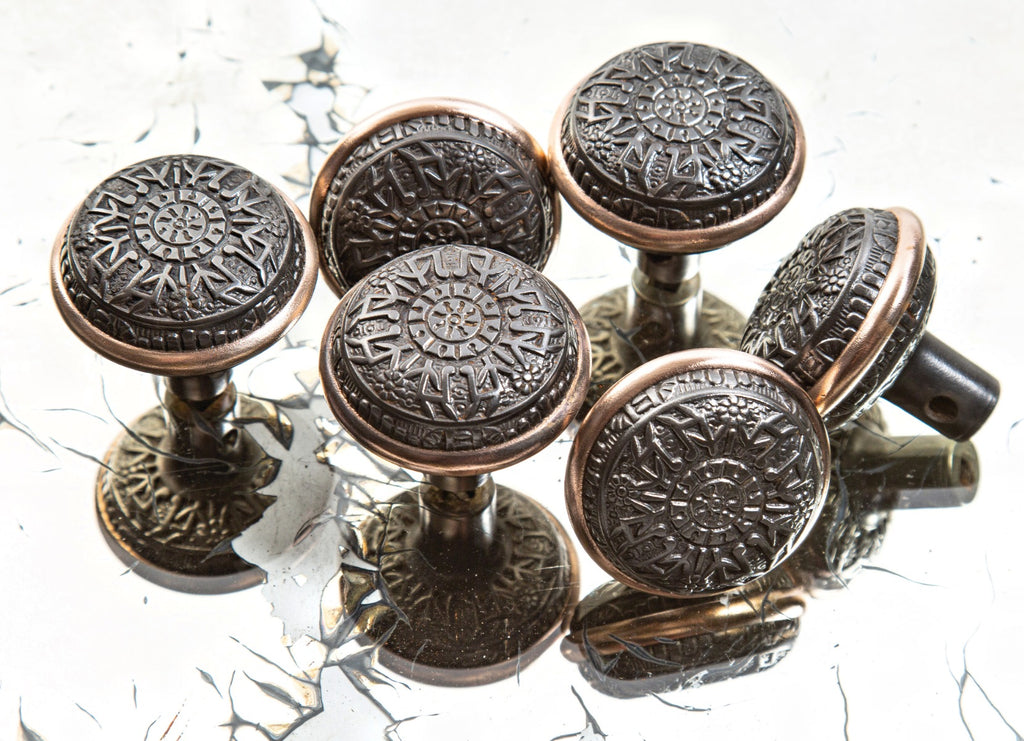 group of hard to find late 19th century eastlake style ornamental cast iron "windsor" pattern residential doorknobs with brass banding