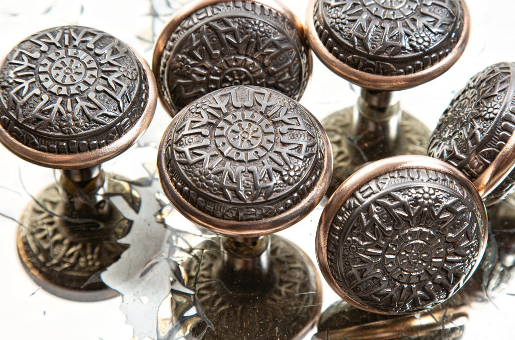 group of hard to find late 19th century eastlake style ornamental cast iron "windsor" pattern residential doorknobs with brass banding