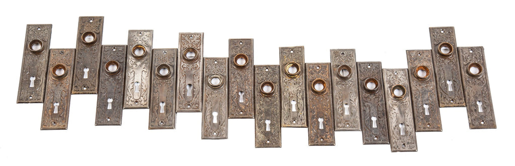 several matching early 20th century american victorian-era architectural doorknob backplates comprised of stamped steel