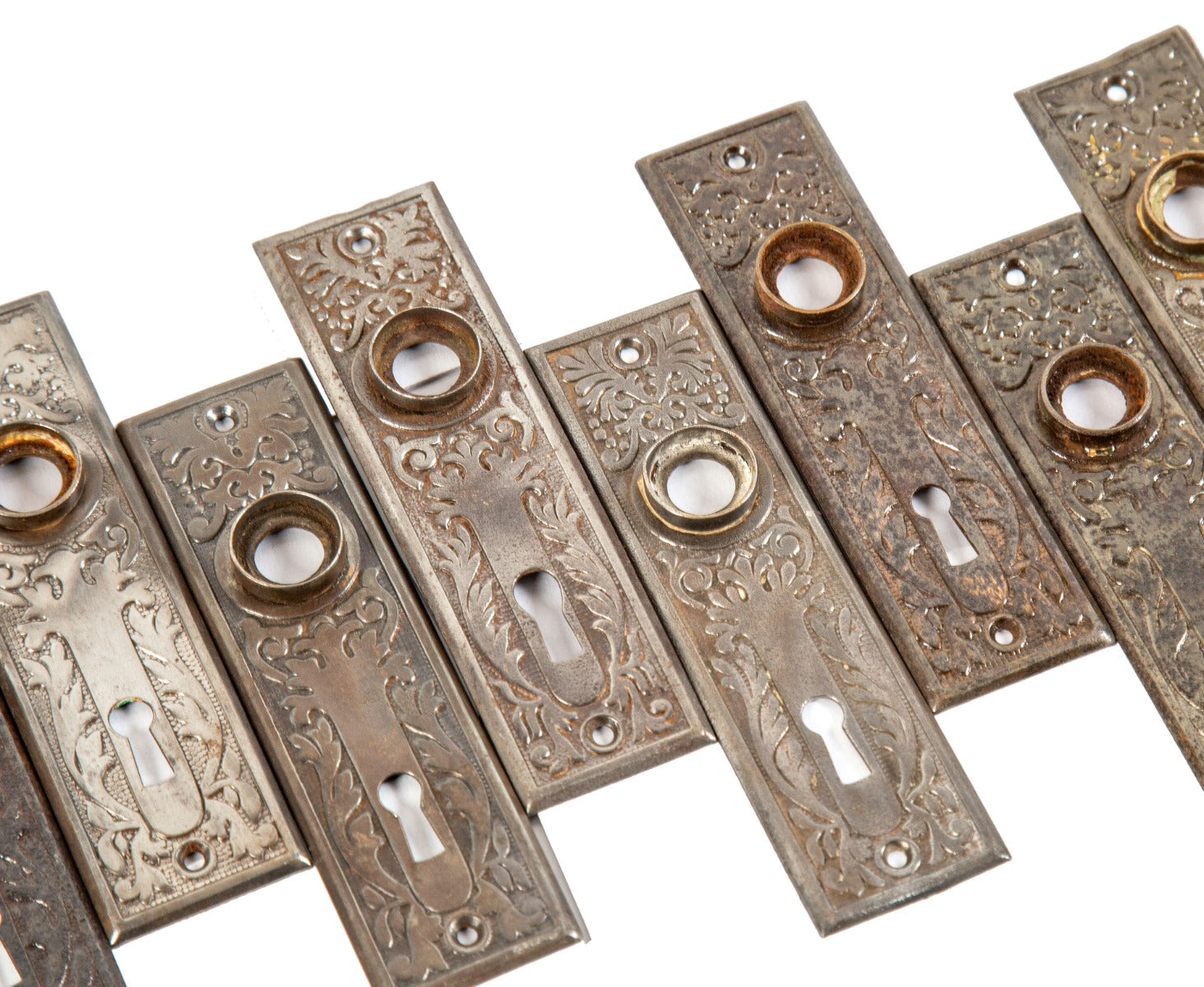 several matching early 20th century american victorian-era architectural doorknob backplates comprised of stamped steel