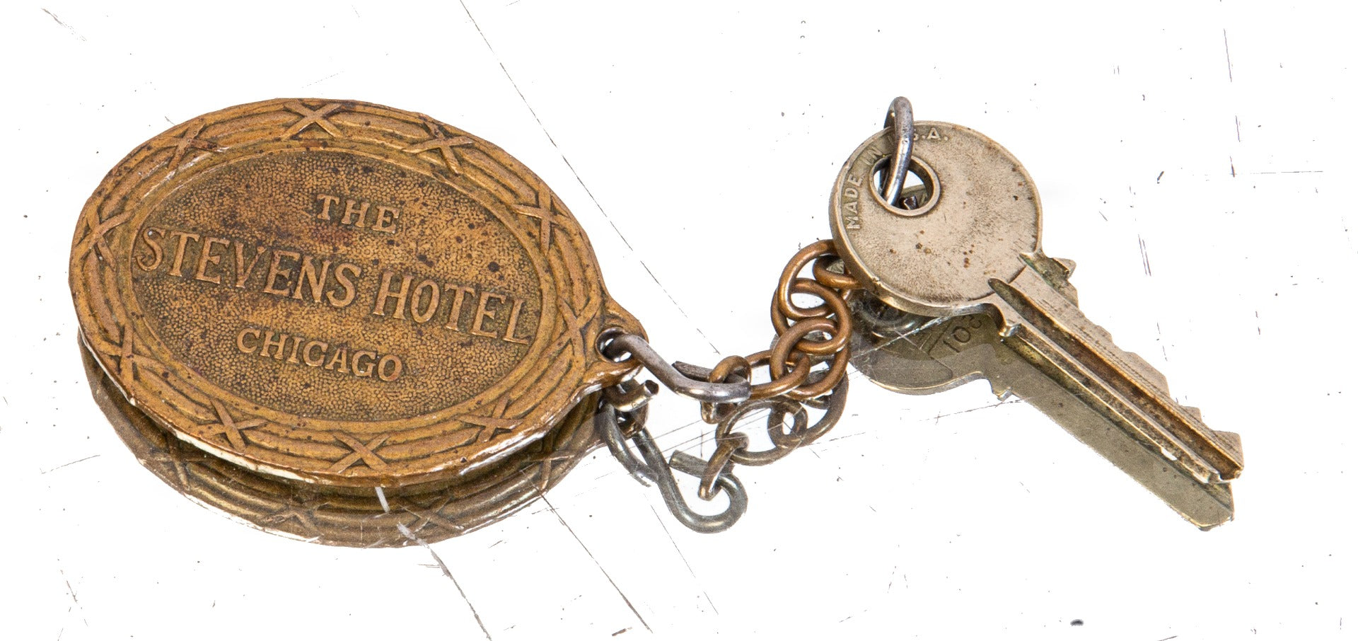 early ornamental cast brass downtown chicago stevens hotel emblematic oval-shaped key fob with rearing lion, shield, and ribbon with hotel name
