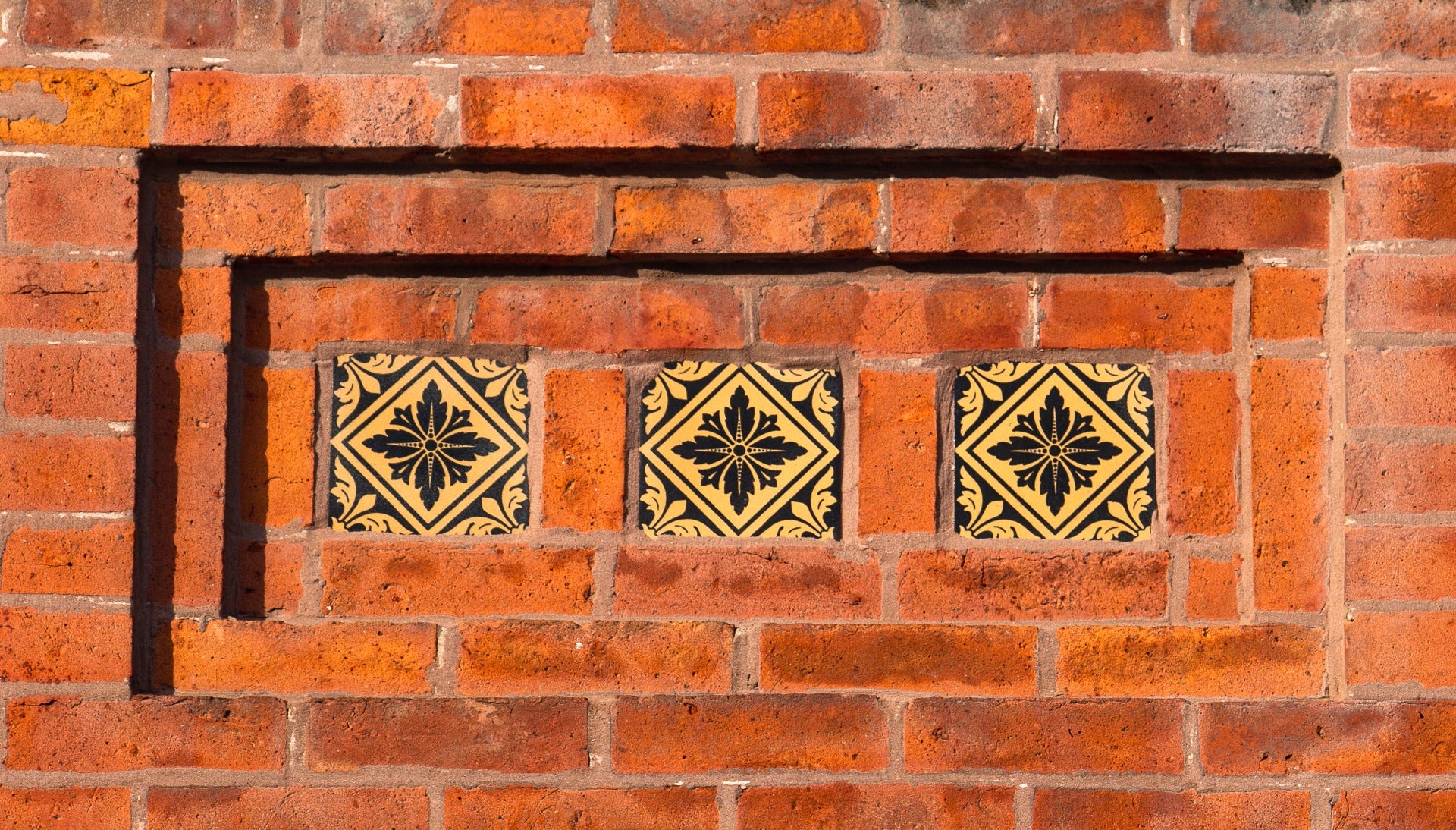group of four matching exterior salvaged chicago black and yellow glazed 1870s facade tiles