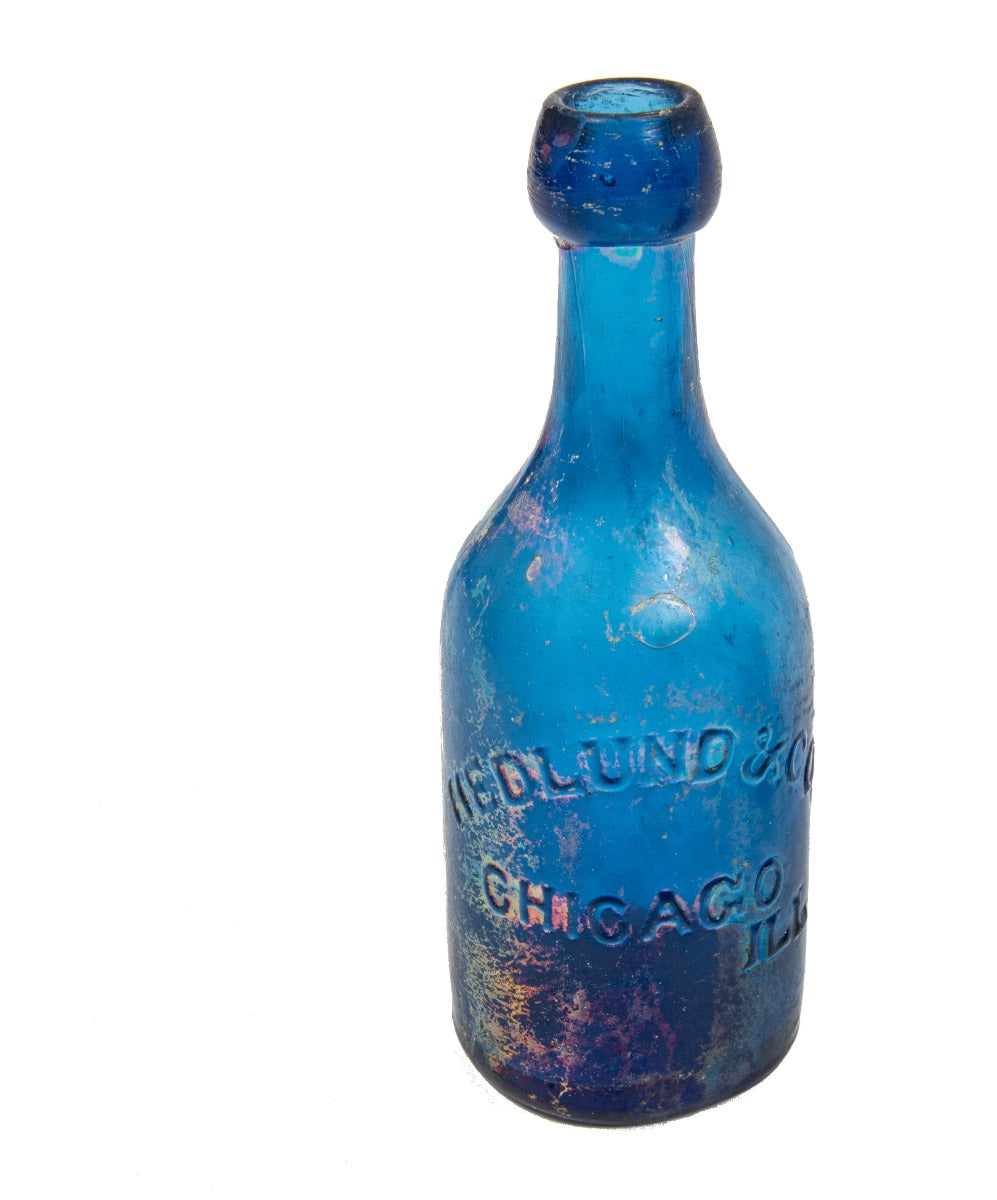 original antique american mid-nineteenth century irridized cobalt blue glass iron-pontiled soda bottle fabricated for john hedlund & company in chicago, ills.