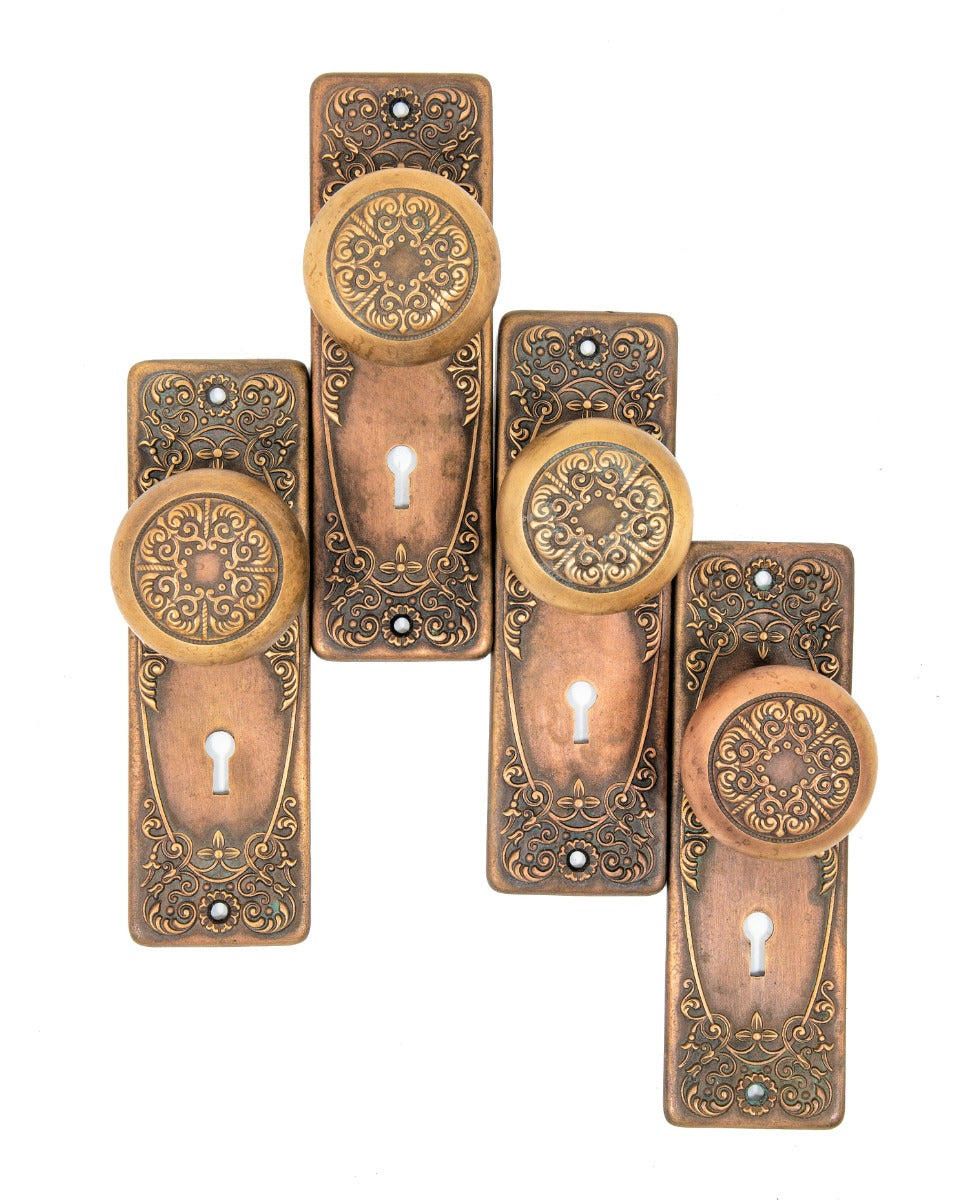 group of matching early 20th century heavy wrought bronze "alexandria" pattern salvaged chicago doorknobs and backplates