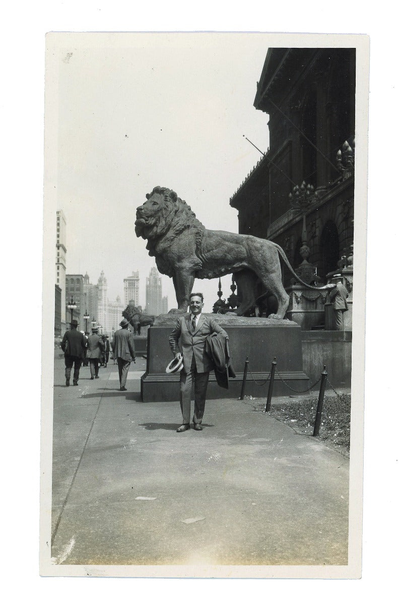 american depression-era single silver gelatin print of man posing in front of art institute of chicago lion