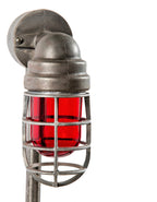 repurposed brushed steel pipe floor lamp with three-legged cast iron base and ruby red explosion proof bulb guard