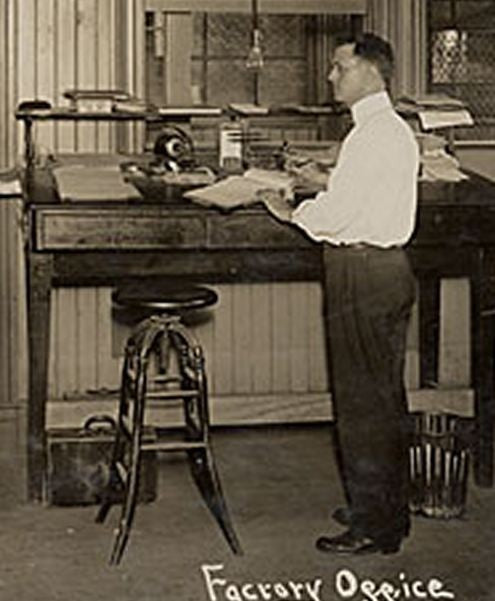 adjustable height turn of the century american antique industrial four-legged oak wood and iron draftsman stool with revolving seat