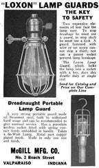 all original and completely intact early 20th century black enameled turned wood handle portable lamp with patented mcgill spring cushion guard or cage