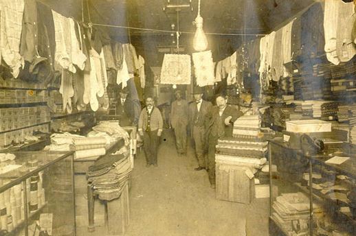 early 20th century american industrial interior clothing store black enameled "dorad" revolving garment rack with weighted cast iron base