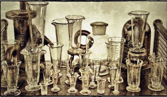 three nearly identical early 20th century antique american apothecary drugstore acid or wheel-cut etched clear glass conical-shaped measures with pedestal bases
