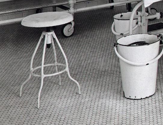 original early 20th century brushed and sanded bare metal antique american medical all welded-joint three-legged stationary operating room stool with original pressed and form seat
