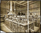 group of four original and intact matching clear glass american industrial research chemistry laboratory reagent bottles with intact circular-shaped tapered ground glass stoppers