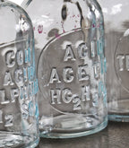 original c. 1930's american depression era antique industrial scientific research laboratory embossed reagent bottles with oversized disc-shaped ground glass stoppers